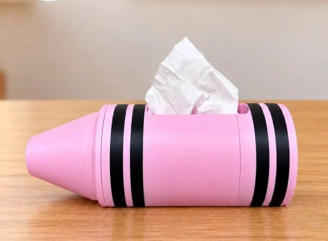 Portapañuelos rosa en forma de crayola sobre un escritorio